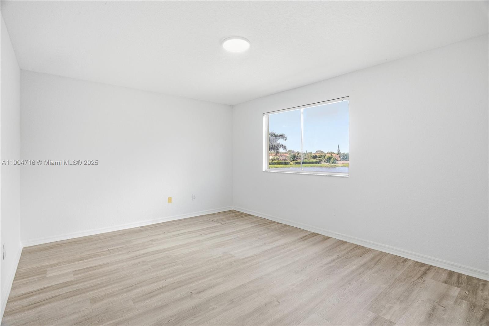 4628 Southwest 125th Lane Miramar, FL 33027 - Photo 31 of 44 an empty room with a wooden floor and window