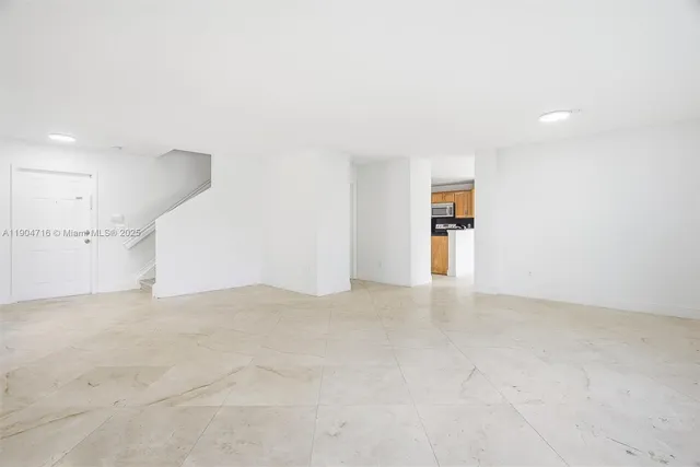 a view of an empty room with kitchen