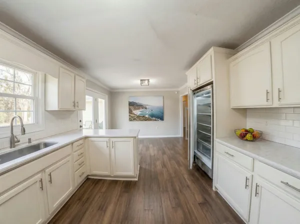 a kitchen with a sink and wooden floor