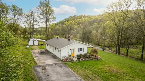 a aerial view of a house with table and chairs under an umbrella