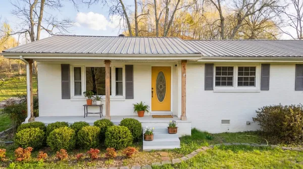 a view of a white house with large windows and a flower garden