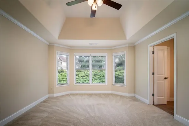 an empty room with windows and chandelier fan