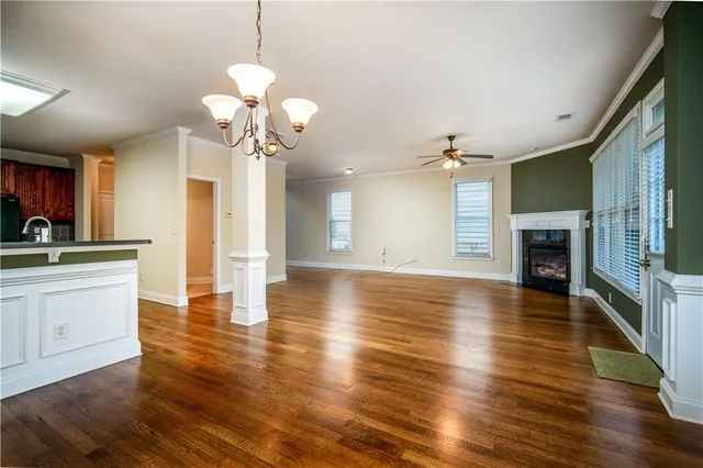 a view of a hallway with wooden floor and a kitchen