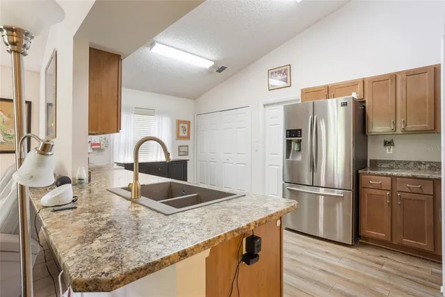 a kitchen with granite countertop a refrigerator and a sink