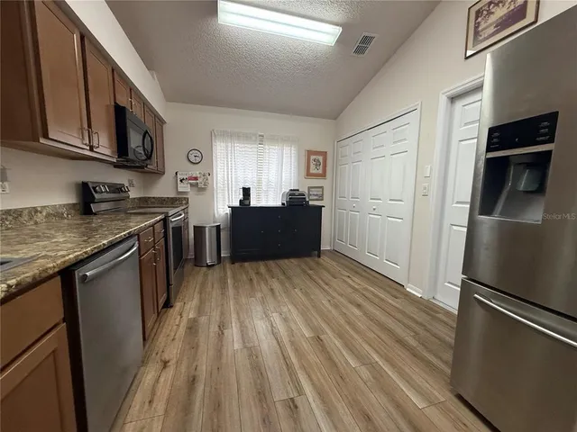 a kitchen with a refrigerator and a stove top oven