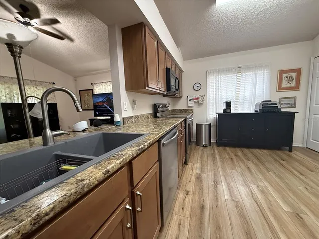 a kitchen with granite countertop a sink stove and cabinets