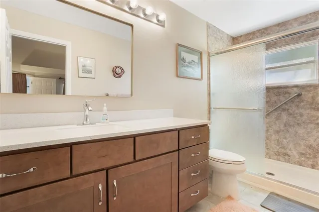 a bathroom with a sink a toilet a shower and a mirror