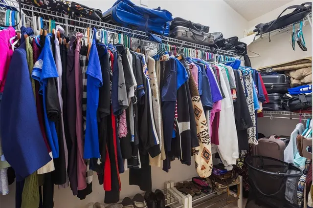 a view of walk in closet with clothes