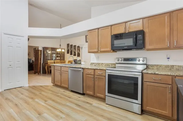 a kitchen with stainless steel appliances granite countertop a stove microwave and sink