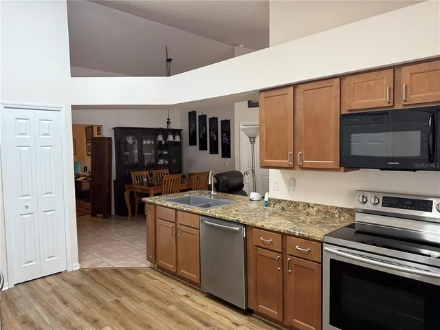 a kitchen with stainless steel appliances granite countertop a sink stove and microwave