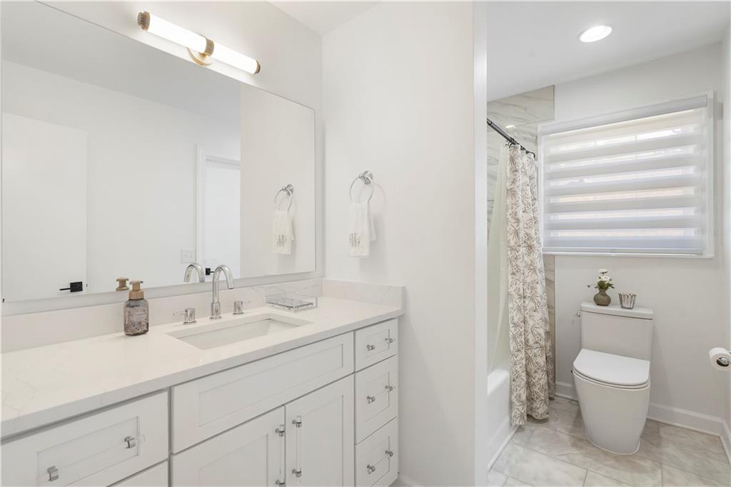 403 Rockbridge Road Southwest Lilburn, GA 30047 - Photo 29 of 77 a bathroom with a double vanity sink toilet and a tub