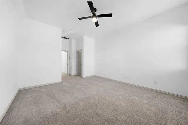 an empty room with a ceiling fan and window