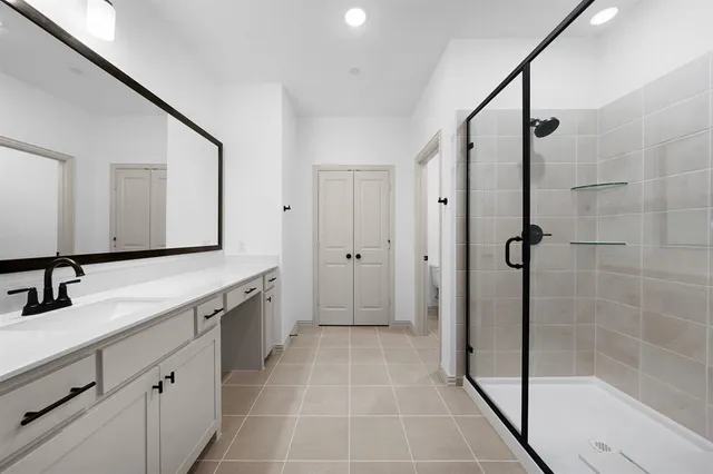 a bathroom with a double vanity sink mirror and shower