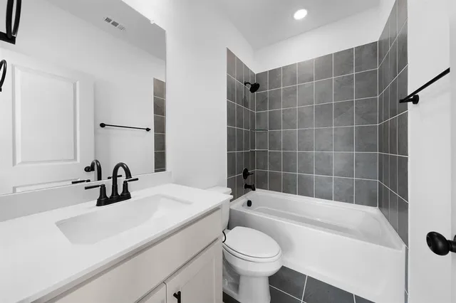 a bathroom with a sink a toilet a mirror a vanity and bathtub