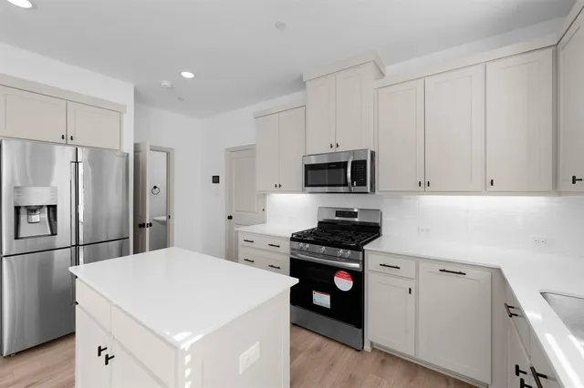 a kitchen with stainless steel appliances a stove microwave and a refrigerator