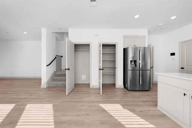 a view of a kitchen with refrigerator and an empty space