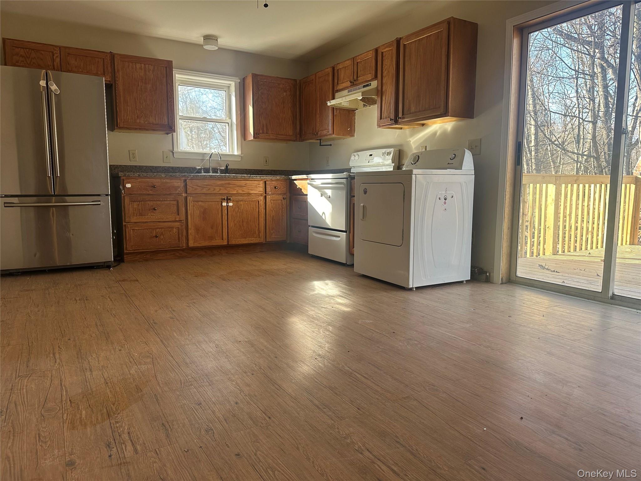 27 Dandelion Lane, Unit A Wallkill, NY 12589 - Photo 5 of 16 a kitchen with stainless steel appliances granite countertop a refrigerator a oven a sink with wooden cabinets and wooden floor