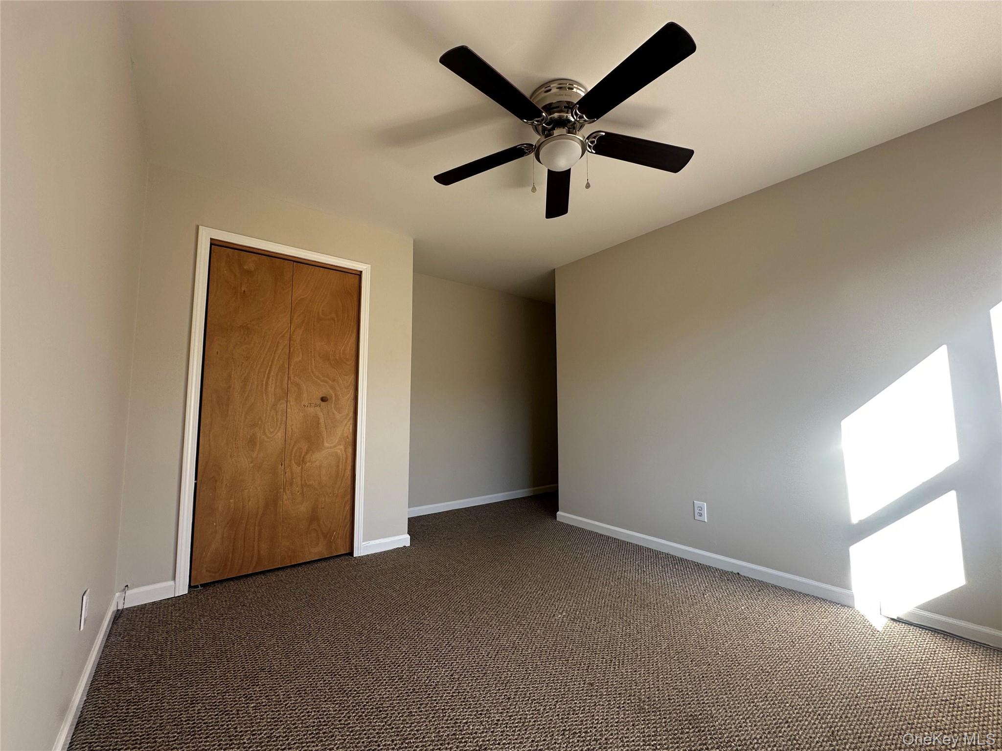 27 Dandelion Lane, Unit A Wallkill, NY 12589 - Photo 10 of 16 an empty room with a ceiling fan and window