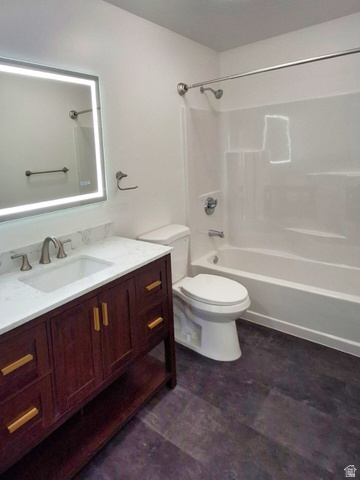 1510 South Lawrence Road Huntington, UT 84528 - Photo 9 of 16 Bathroom featuring a dark wood-finish vanity with a white countertop and rectangular sink, an illuminated mirror, a white toilet, a white bathtub with a shower, and dark wood-finish flooring