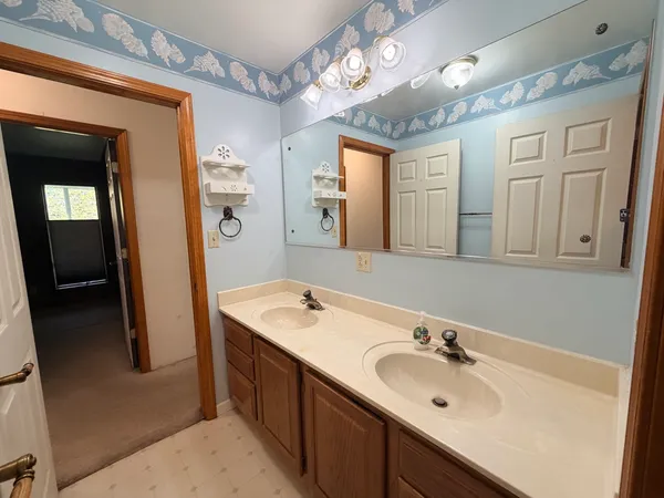 a bathroom with a double vanity sink mirror and bathtub