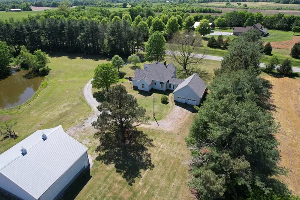 an aerial view of a house with a yard and lake view