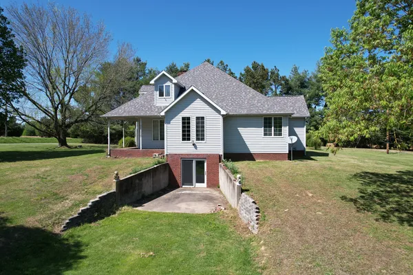 a front view of a house with a yard and trees