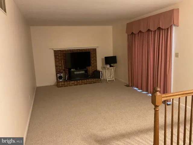 a living room with furniture a flat screen tv and a large window