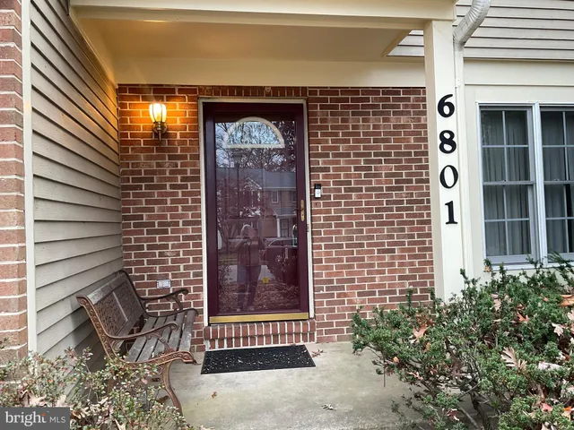 a brick building with a door and a bench