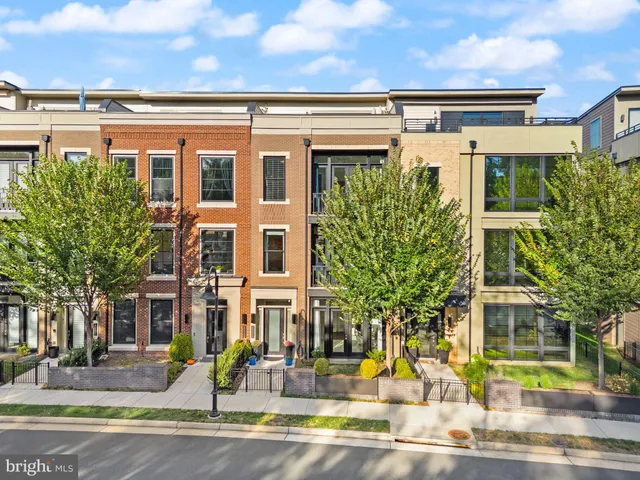 a kitchen with stainless steel appliances kitchen island granite countertop a table chairs refrigerator and microwave