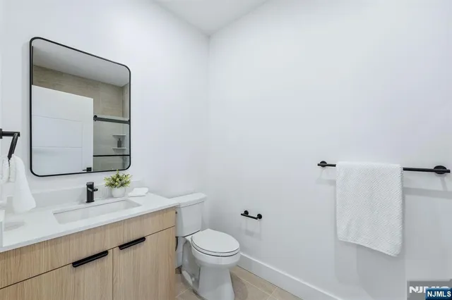 a bathroom with a toilet a sink a mirror and vanity