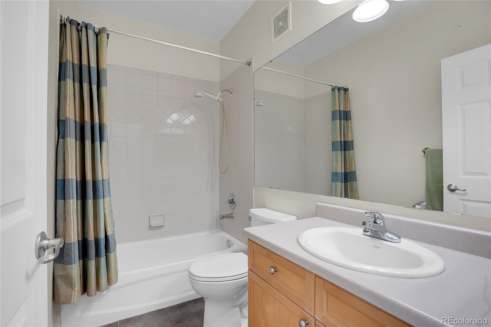 2848 Syracuse Street, Unit 128 Denver, CO 80238 - Photo 11 of 15 a bathroom with a sink a toilet and shower