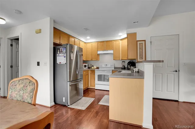 a kitchen with stainless steel appliances granite countertop a refrigerator and a stove top oven