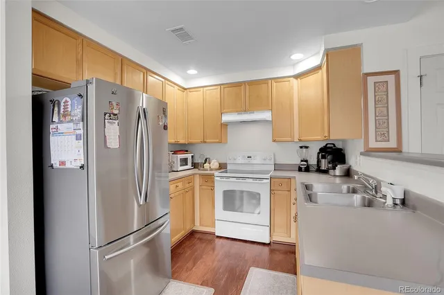 a kitchen with stainless steel appliances a refrigerator sink and microwave