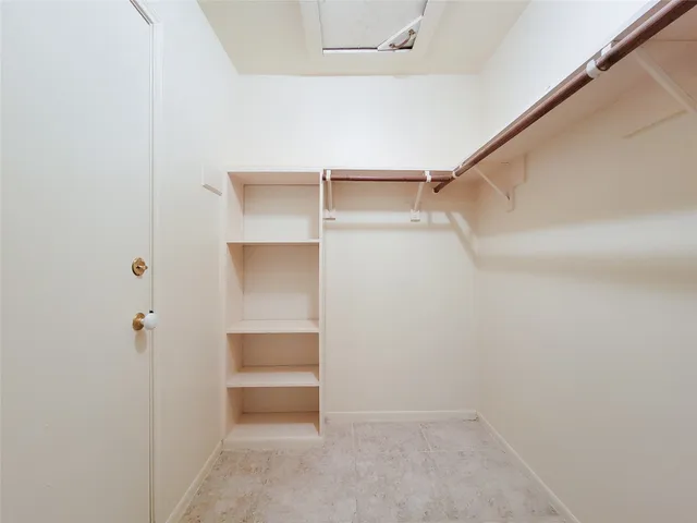 a view of walk in closet with empty racks