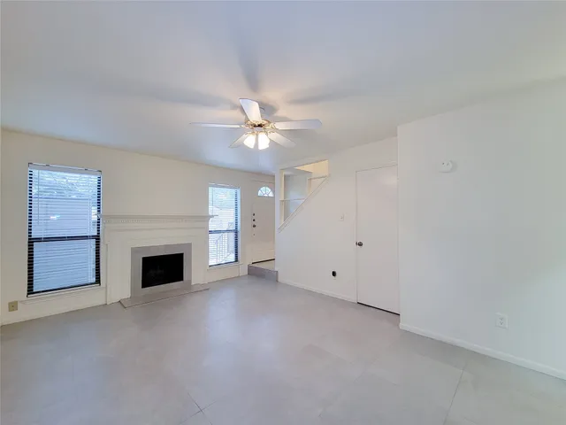 a view of a livingroom with a fireplace and a ceiling fan