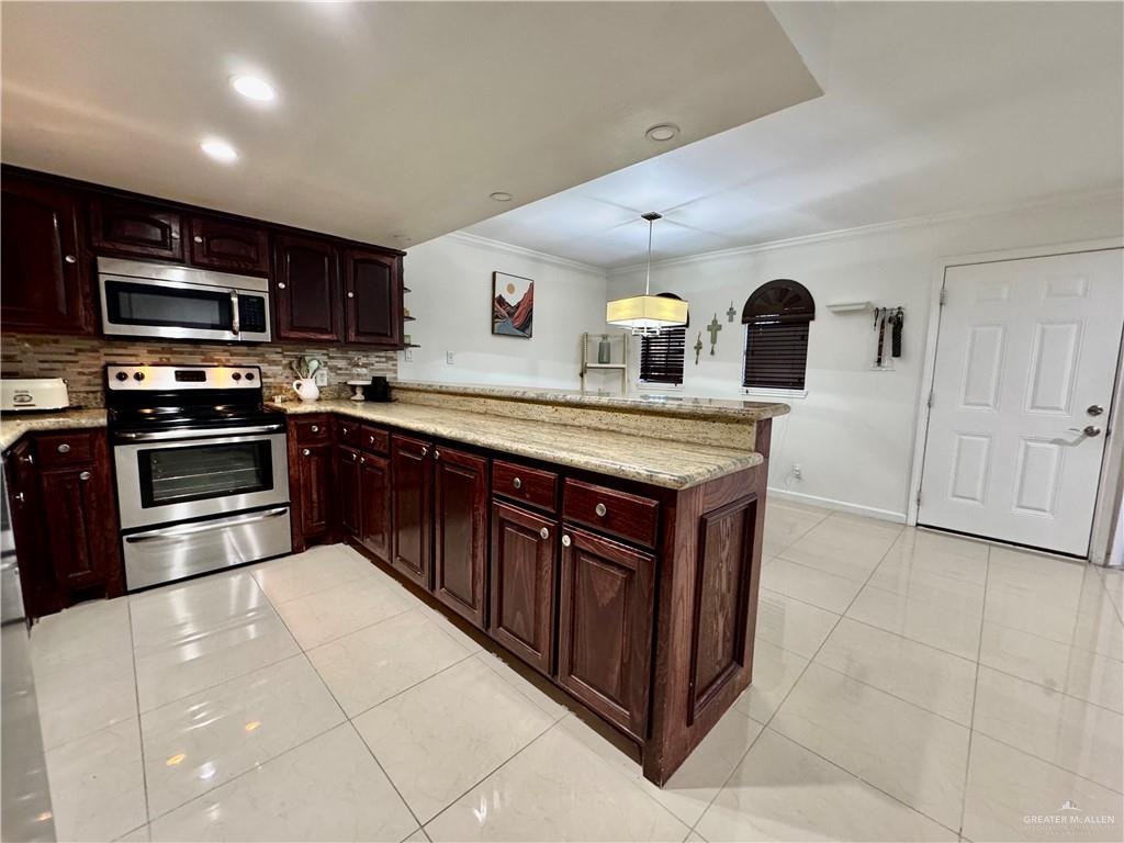 2708 Howard Drive, Unit E3 McAllen, TX 78503 - Photo 14 of 30 a kitchen with stainless steel appliances granite countertop a stove a sink and a microwave