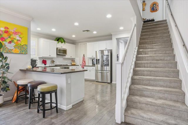a kitchen with stainless steel appliances granite countertop a refrigerator and a stove top oven