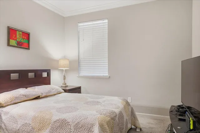 a bedroom with a bed and a lamp on dresser