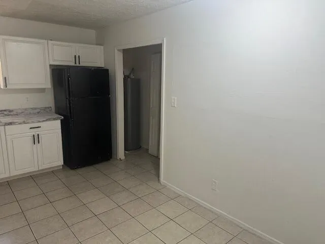 a kitchen with a refrigerator and cabinets