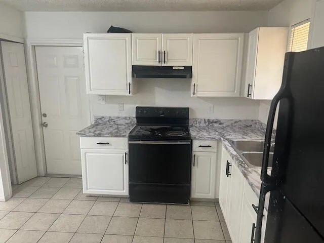 a kitchen with a stove top oven and cabinets