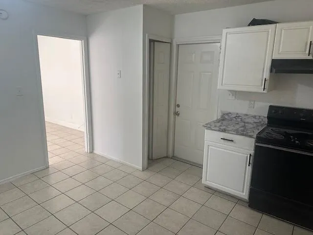 a kitchen with white cabinets and black appliances