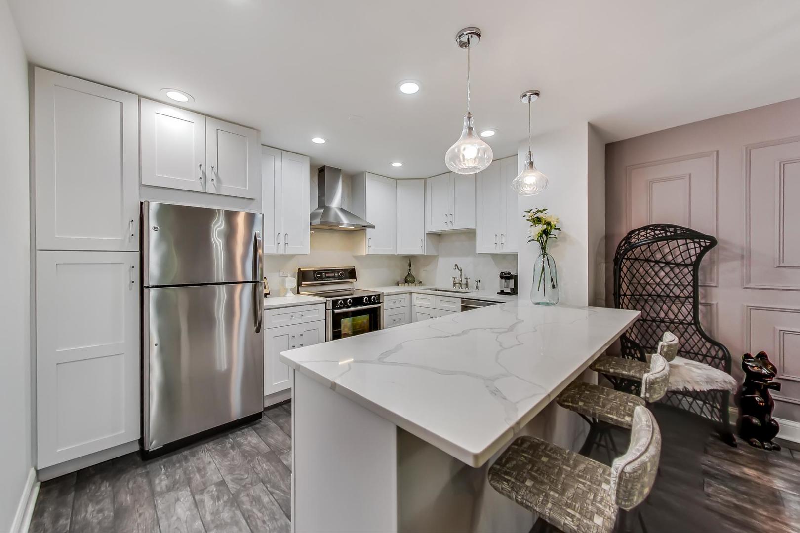 250 Ridge Avenue, Unit 3K Evanston, IL 60202 - Photo 5 of 24 a kitchen with kitchen island a stove a refrigerator and a sink