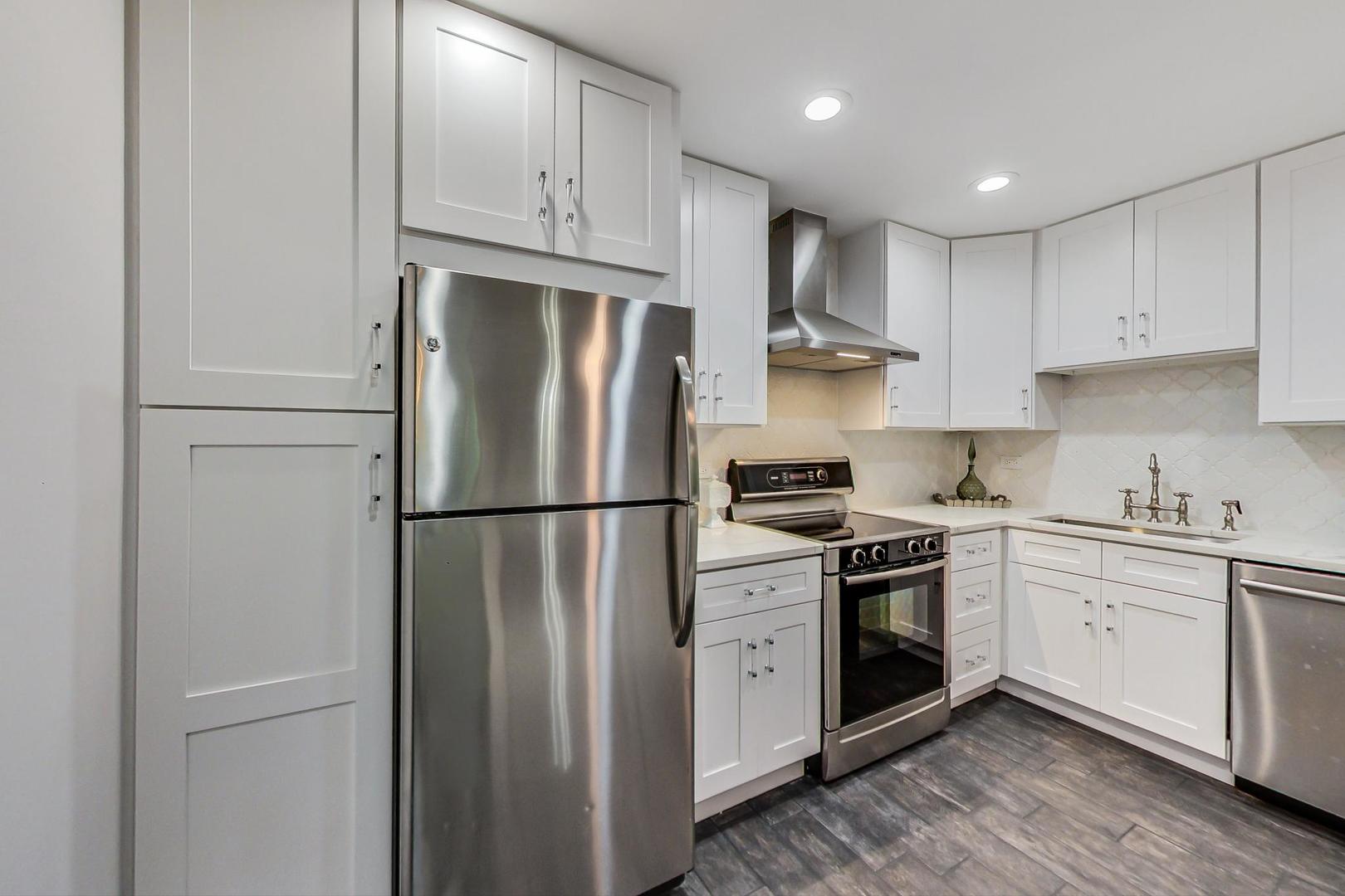 250 Ridge Avenue, Unit 3K Evanston, IL 60202 - Photo 6 of 24 a kitchen with stainless steel appliances granite countertop a refrigerator stove a sink and cabinets