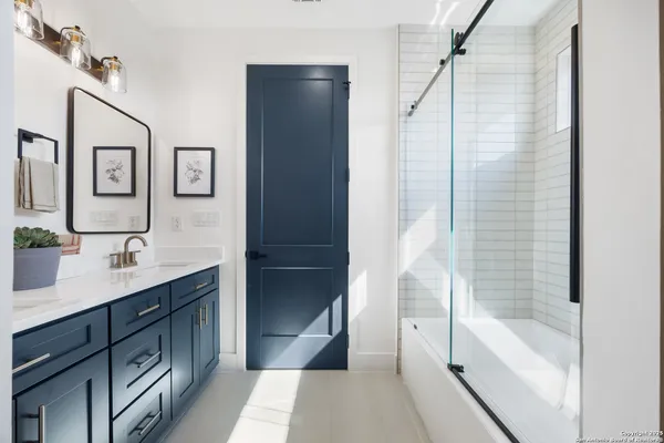 a bathroom with a tub sink and mirror