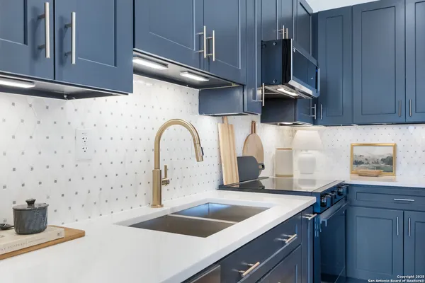 a kitchen with a sink and a stove with wooden floor