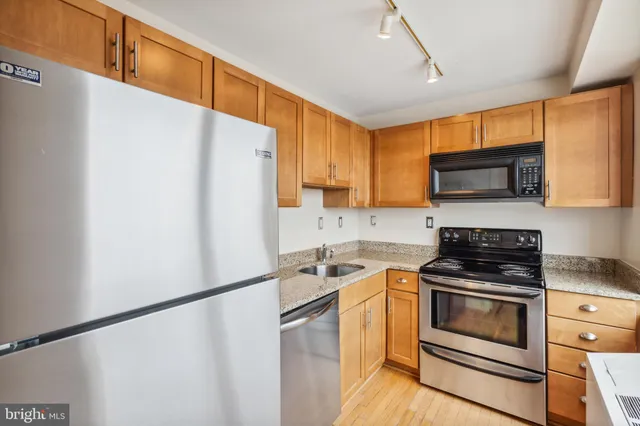 a kitchen with granite countertop a refrigerator stove and microwave