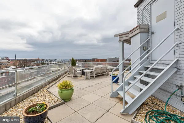 a view of a terrace with lawn chairs