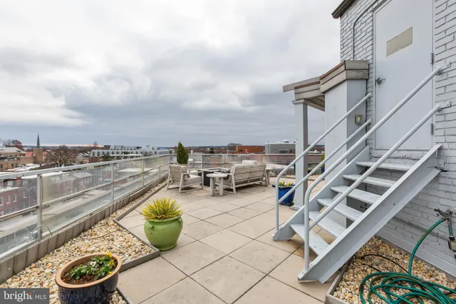 a view of a terrace with lawn chairs
