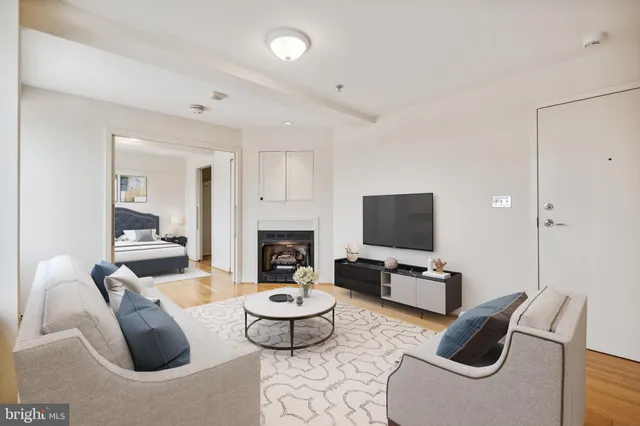 a living room with furniture a rug a fireplace and a flat screen tv