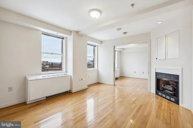 an empty room with windows and a fireplace